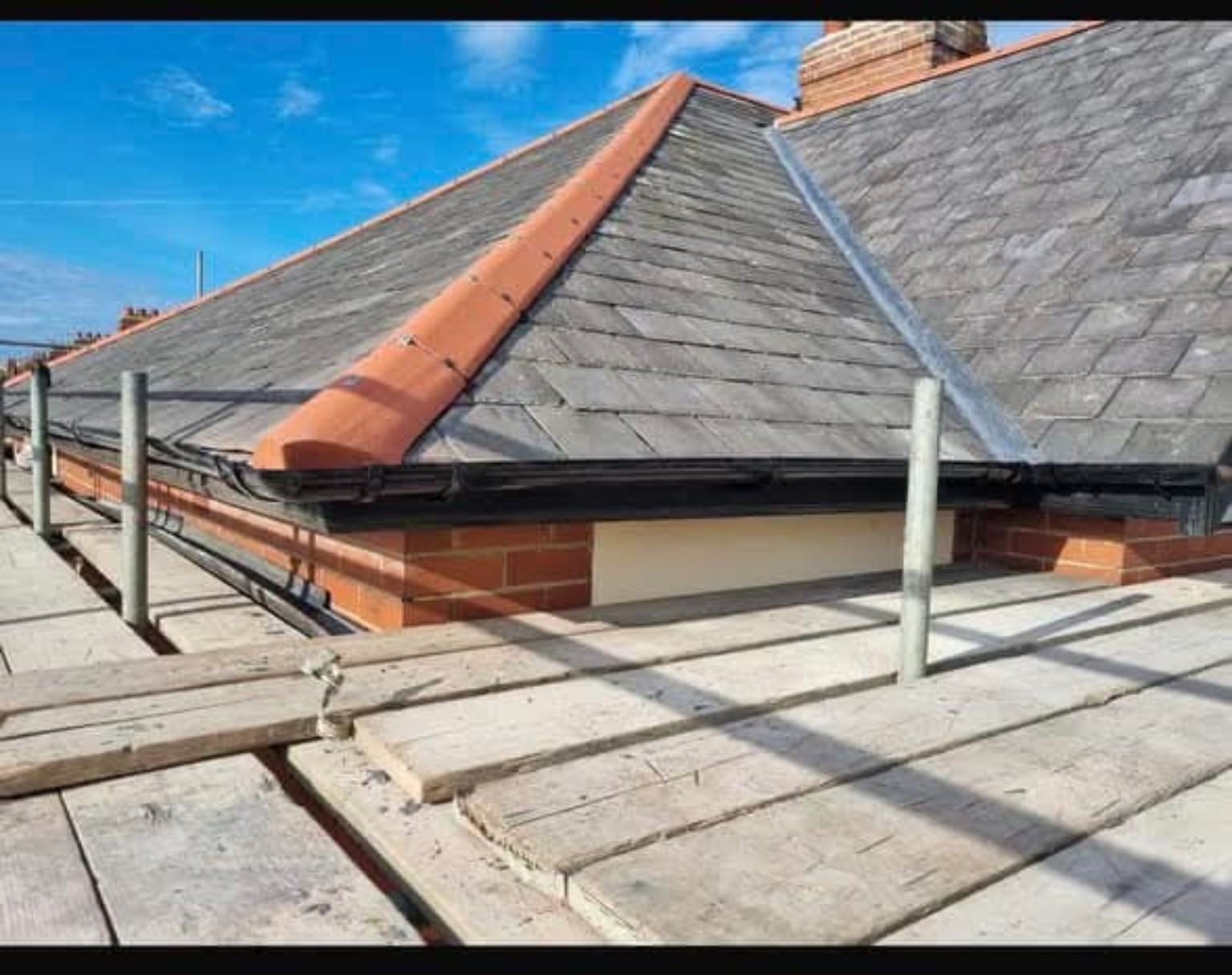 Slate roof with ridge tiles and scaffolding